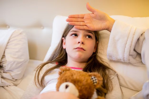 A child feeling unwell, with an adult checking her temperature by placing a hand on her forehead.
